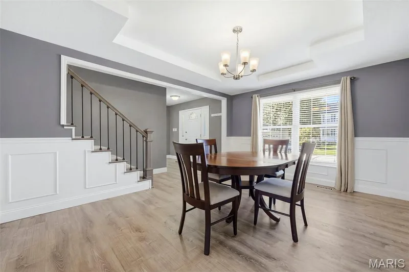 Dining Room with tray ceiling, chair rail with wainscoting and picture molding; adjoins Foyer, Kitchen, and front staircase. — 386 Beckley Place, St Charles, MO 63304