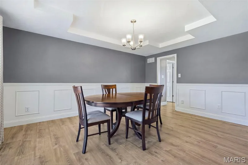 Dining Room with tray ceiling, chair rail with wainscoting and picture molding; adjoins Foyer, Kitchen, and front staircase. — 386 Beckley Place, St Charles, MO 63304