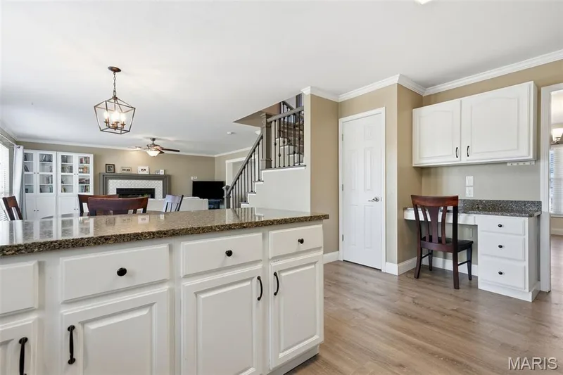 Kitchen with granite countertops, peninsula island counter seating for four, pantry, family desk, and stainless-steel appliances. Adjoins: Breakfast Area, Dining Room, and Mud Room with Laundry. — 386 Beckley Place, St Charles, MO 63304