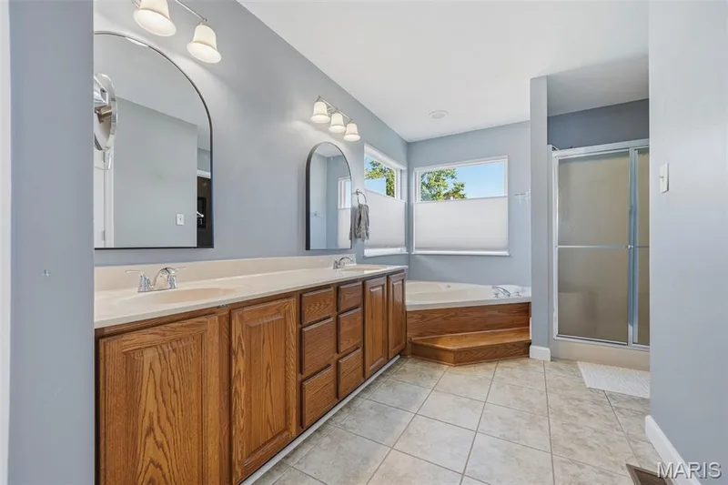 En Suite Primary Bathroom with double vanities, jet tub, shower, and water closet. — 386 Beckley Place, St Charles, MO 63304