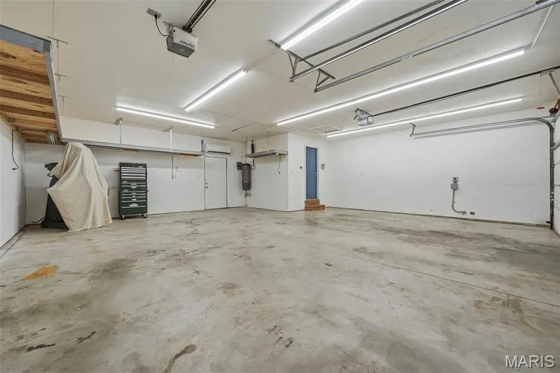 Fully insulated/drywalled and heated/cooled, oversized 3 car garage (29' x 20') with Workshop (21' x 9'), LED lighting, and EV ready charging station; door to Mudroom with Laundry and exterior door to rear deck. — 386 Beckley Place, St Charles, MO 63304