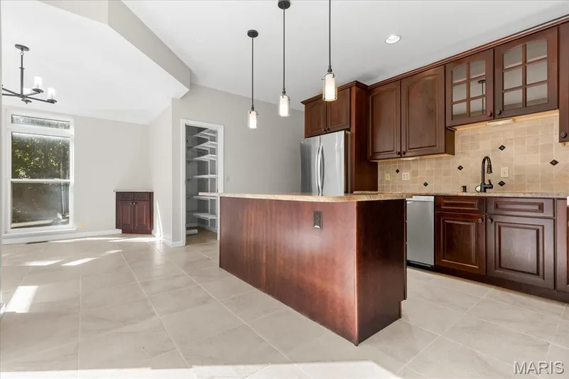 Center island with granite counter tops and stainless steel appliances — 16 Regatta Bay Court, Lake St. Louis, MO 63367