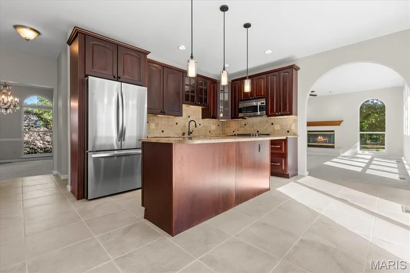 Center island with granite counter tops and stainless steel appliances — 16 Regatta Bay Court, Lake St. Louis, MO 63367
