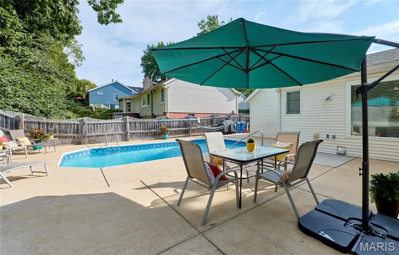 Backyard with an in-ground swimming pool, concrete patio, and slatted wood fencing — 1843 Shadywood Court, Chesterfield, MO 63017