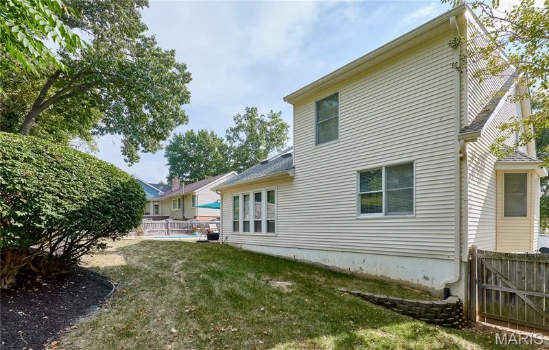 Exterior featuring horizontal siding, multiple windows, and a retaining wall — 1843 Shadywood Court, Chesterfield, MO 63017