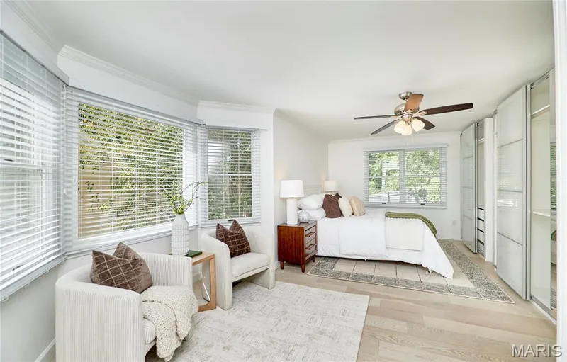 Light wood-finish flooring, built-in wardrobe system, ceiling fan with light, and multiple windows with blinds — 1843 Shadywood Court, Chesterfield, MO 63017