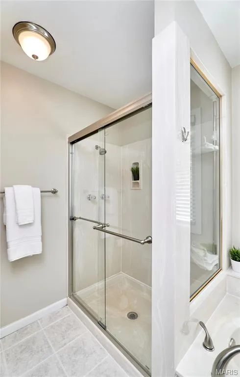 Glass-enclosed shower with brushed nickel hardware, tiled flooring, and a built-in shower niche — 1843 Shadywood Court, Chesterfield, MO 63017