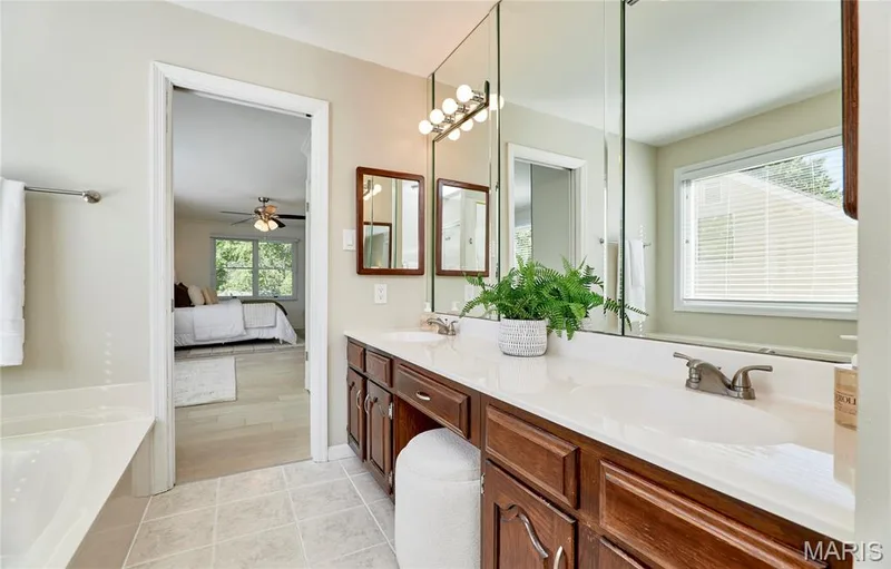 Double vanity with integrated sinks, white countertops, and wood-finish cabinetry — 1843 Shadywood Court, Chesterfield, MO 63017