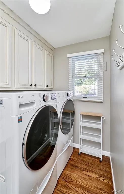 MAIN FLOOR LAUNDRY Upper cabinetry with panel detailing, wood-finish flooring, and natural light from the window — 1843 Shadywood Court, Chesterfield, MO 63017