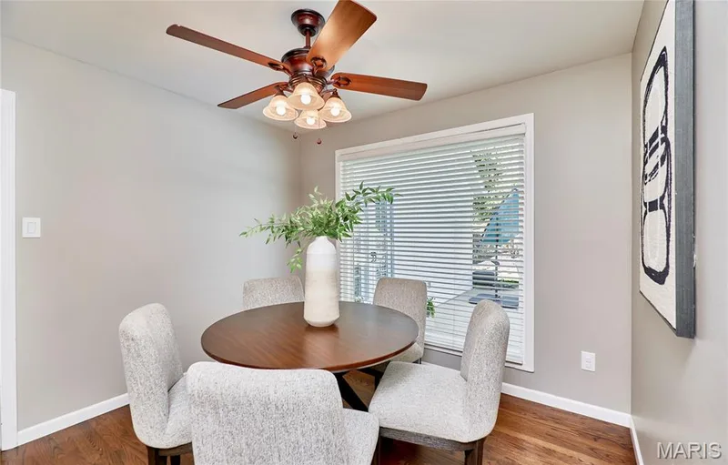 Hardwood-finish flooring, a ceiling fan with integrated lighting, and a large window with blinds — 1843 Shadywood Court, Chesterfield, MO 63017