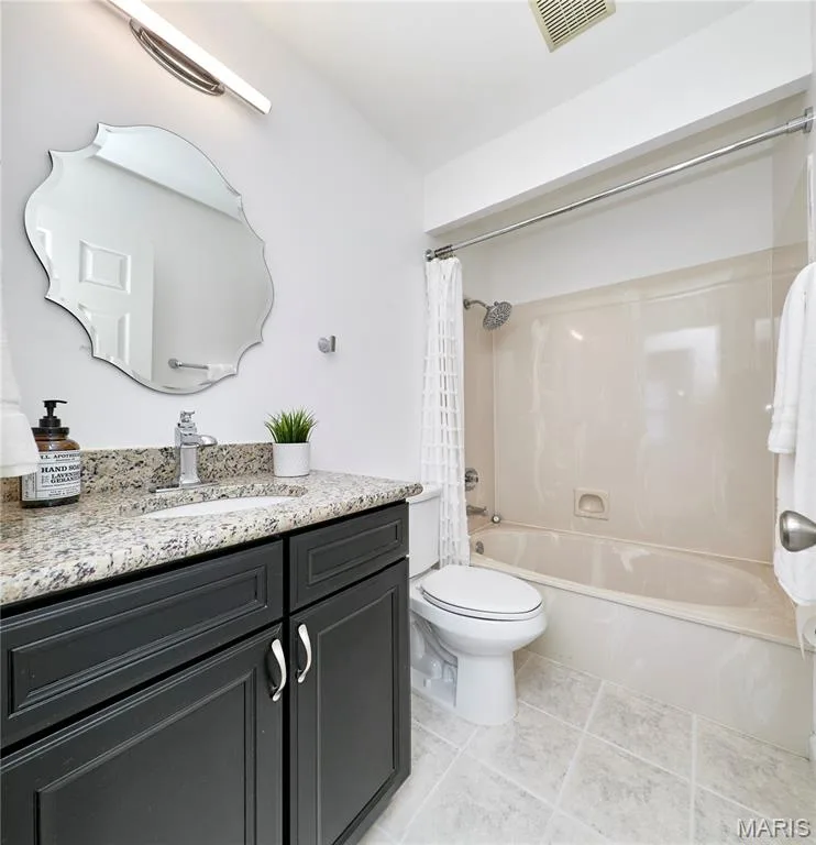 Bathroom featuring a dark wood-finish vanity with a light granite countertop, an undermount sink, and a chrome faucet — 1843 Shadywood Court, Chesterfield, MO 63017