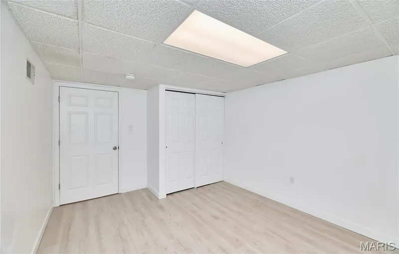 Recessed lighting panel, white paneled door, wood-finish flooring, and a drop ceiling — 1843 Shadywood Court, Chesterfield, MO 63017