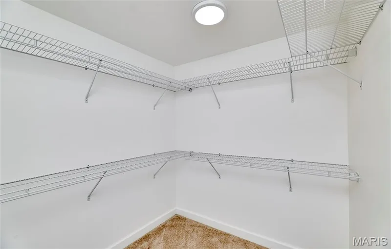 White walls with wire shelving, integrated ceiling light fixture, and carpeted flooring — 1843 Shadywood Court, Chesterfield, MO 63017