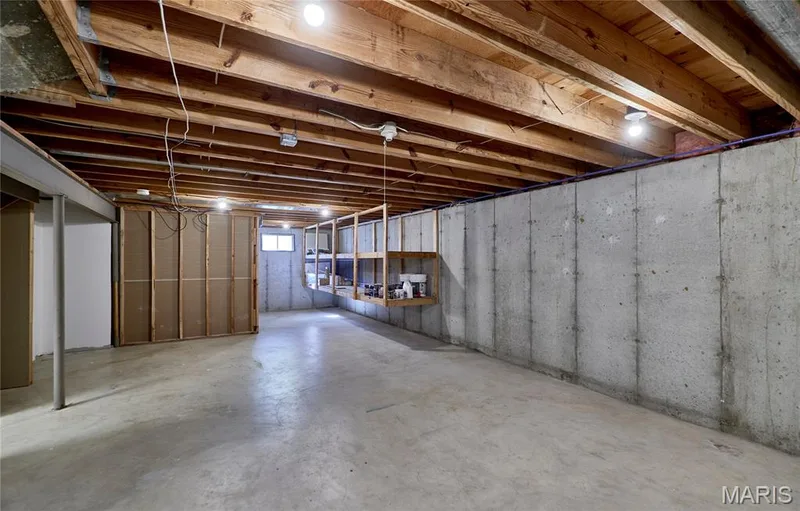 Unfinished basement featuring exposed wood joists, concrete floor, and framed wall sections — 1843 Shadywood Court, Chesterfield, MO 63017