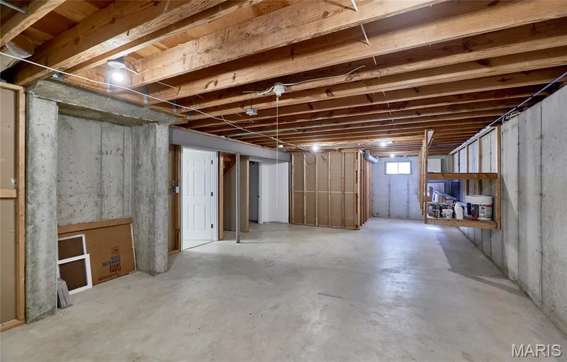 Exposed wood ceiling beams, concrete flooring, built-in wooden shelving, and a small window — 1843 Shadywood Court, Chesterfield, MO 63017