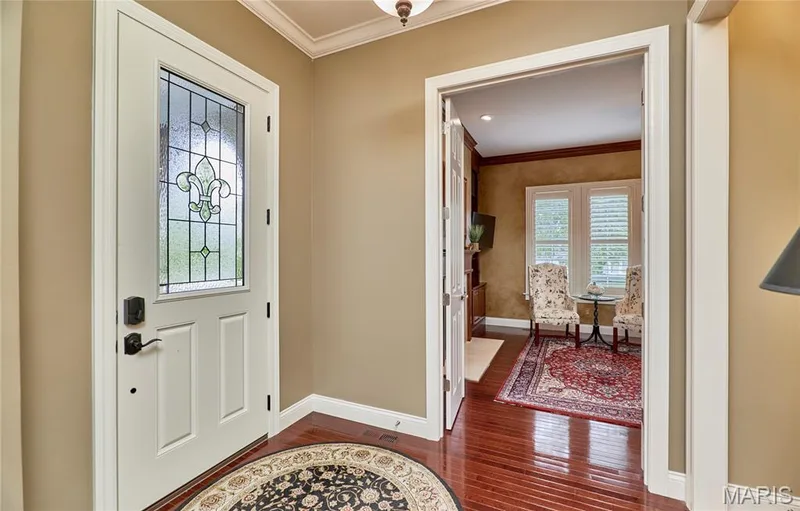 Entryway featuring a decorative glass door, crown molding, and wood-finish flooring — 1970 Chesterfield Ridge Circle, Chesterfield, MO 63017