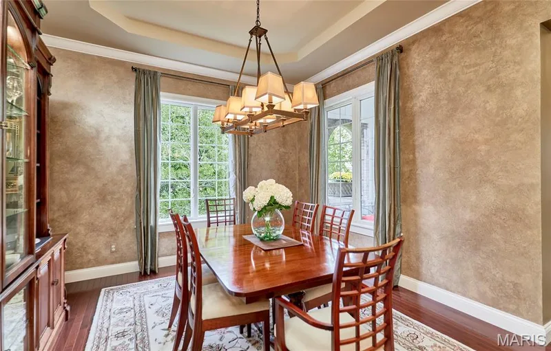 Tray ceiling with crown molding, decorative wall finish, hardwood flooring, and a chandelier — 1970 Chesterfield Ridge Circle, Chesterfield, MO 63017