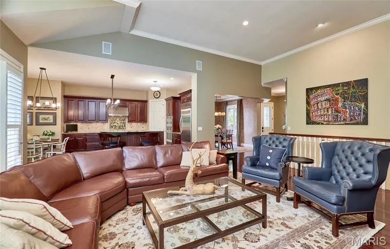 Spacious open-concept living area featuring high ceilings, wood-finish flooring, and crown molding — 1970 Chesterfield Ridge Circle, Chesterfield, MO 63017