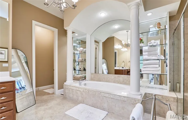 Built-in soaking tub with stone surround, complemented by a decorative arched alcove — 1970 Chesterfield Ridge Circle, Chesterfield, MO 63017
