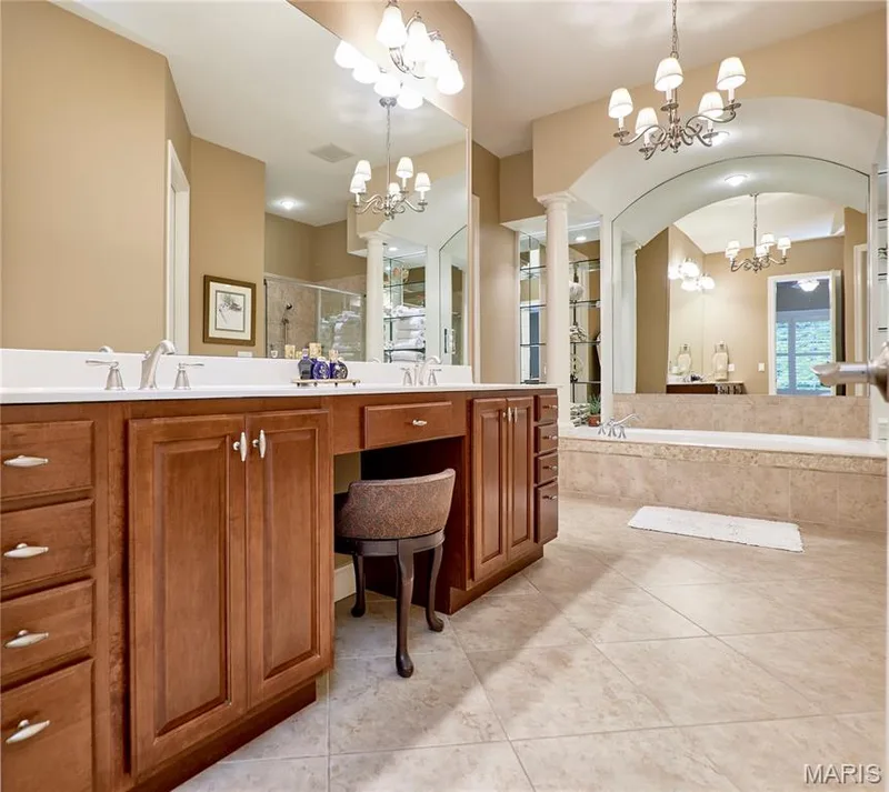 Dual vanity with integrated makeup area, built-in soaking tub, tiled flooring, and arched wall feature — 1970 Chesterfield Ridge Circle, Chesterfield, MO 63017