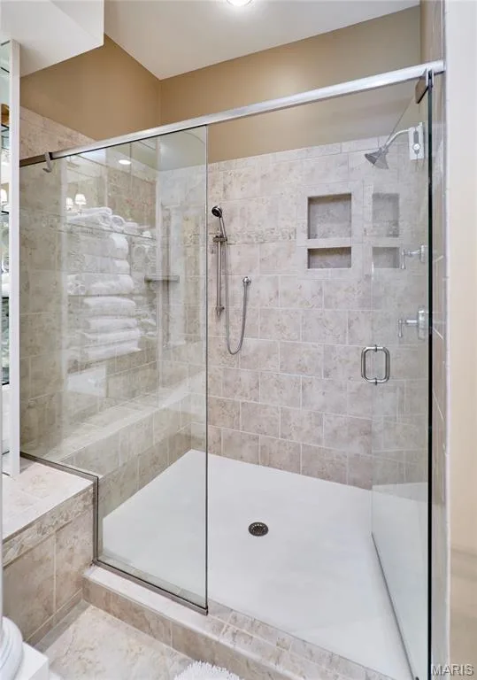 Glass-enclosed shower with a tiled surround, recessed shelving, and a dual-head shower system — 1970 Chesterfield Ridge Circle, Chesterfield, MO 63017