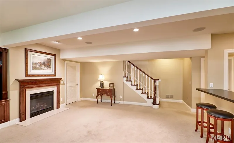 Built-in fireplace with wood-finish mantel and hearth, carpeted flooring, recessed lighting, and a staircase with wood-finish handrail and white balusters — 1970 Chesterfield Ridge Circle, Chesterfield, MO 63017