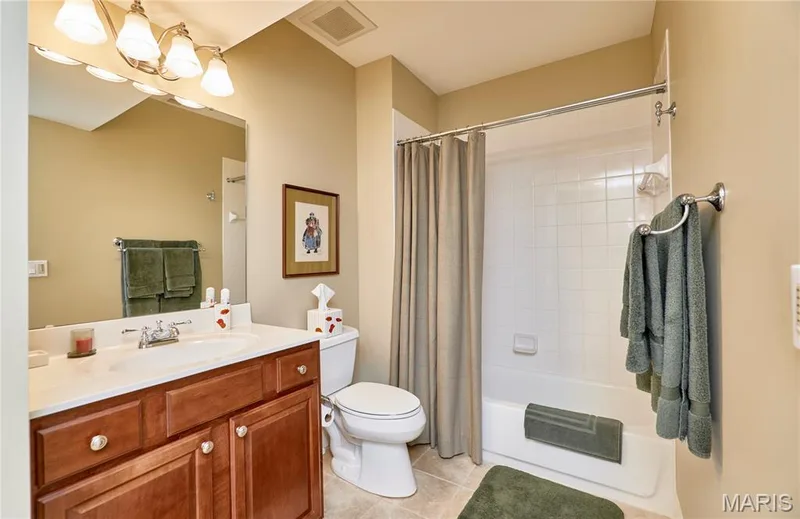 Vanity with cherry wood-finish cabinetry, white countertop, and integrated sink — 1970 Chesterfield Ridge Circle, Chesterfield, MO 63017