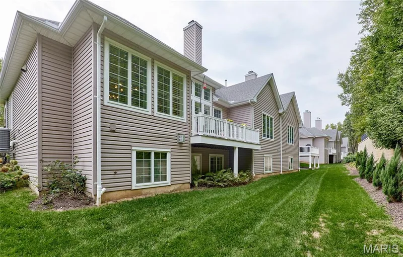 Exterior with horizontal siding, multiple windows with grilles, white deck railing, and a sloped shingle roof — 1970 Chesterfield Ridge Circle, Chesterfield, MO 63017