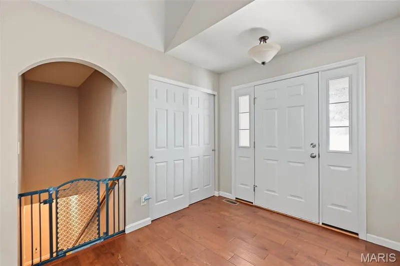 Entryway with wood-finish flooring, a paneled front door with sidelights, and bi-fold closet doors — 521 Sceptre Road, Wentzville, MO 63385