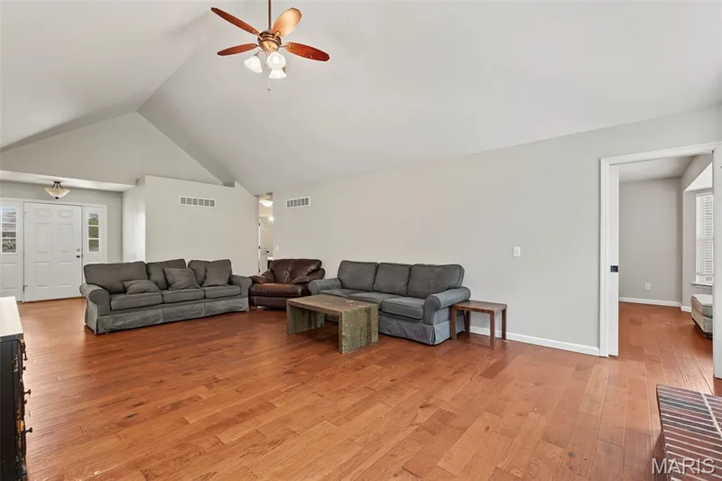 Vaulted ceiling with a ceiling fan, wood-finish flooring, and a white entry door with sidelights — 521 Sceptre Road, Wentzville, MO 63385