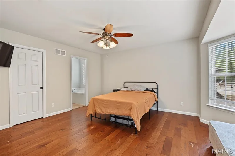 Hardwood-style flooring, a ceiling fan with light fixture, and a window with white blinds — 521 Sceptre Road, Wentzville, MO 63385