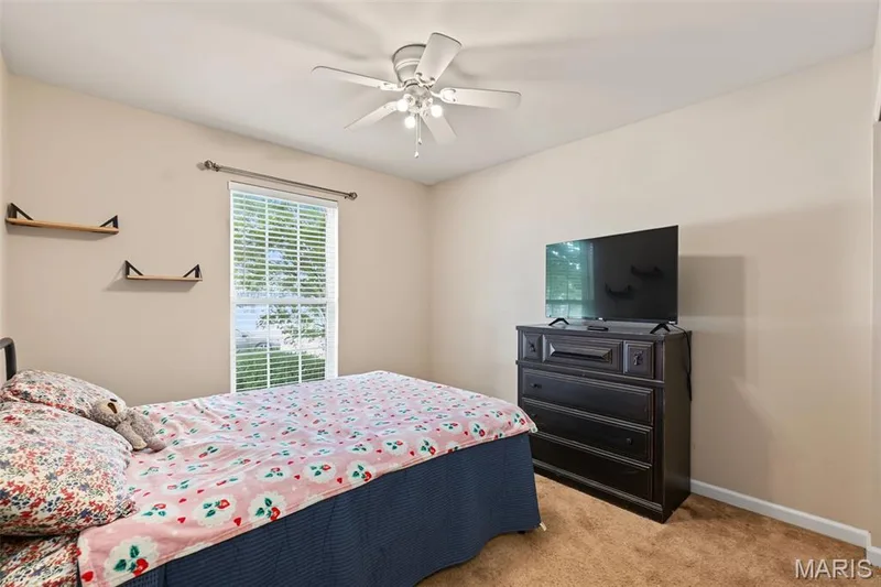 Carpeted flooring, window with blinds, ceiling fan with light fixture, light-toned wall paint, decorative wall shelving — 521 Sceptre Road, Wentzville, MO 63385