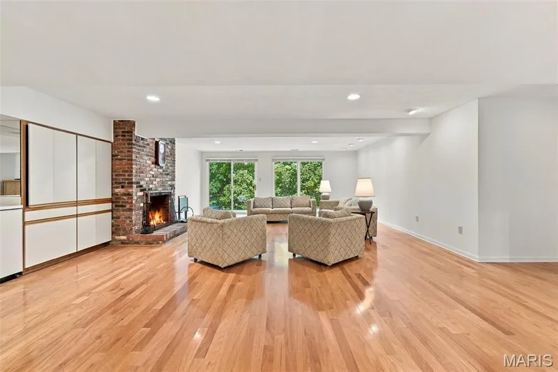 Hardwood flooring throughout, a brick fireplace, built-in cabinetry, recessed lighting, Walks out to patio — 14033 Baywood Villages Drive, Chesterfield, MO 63017