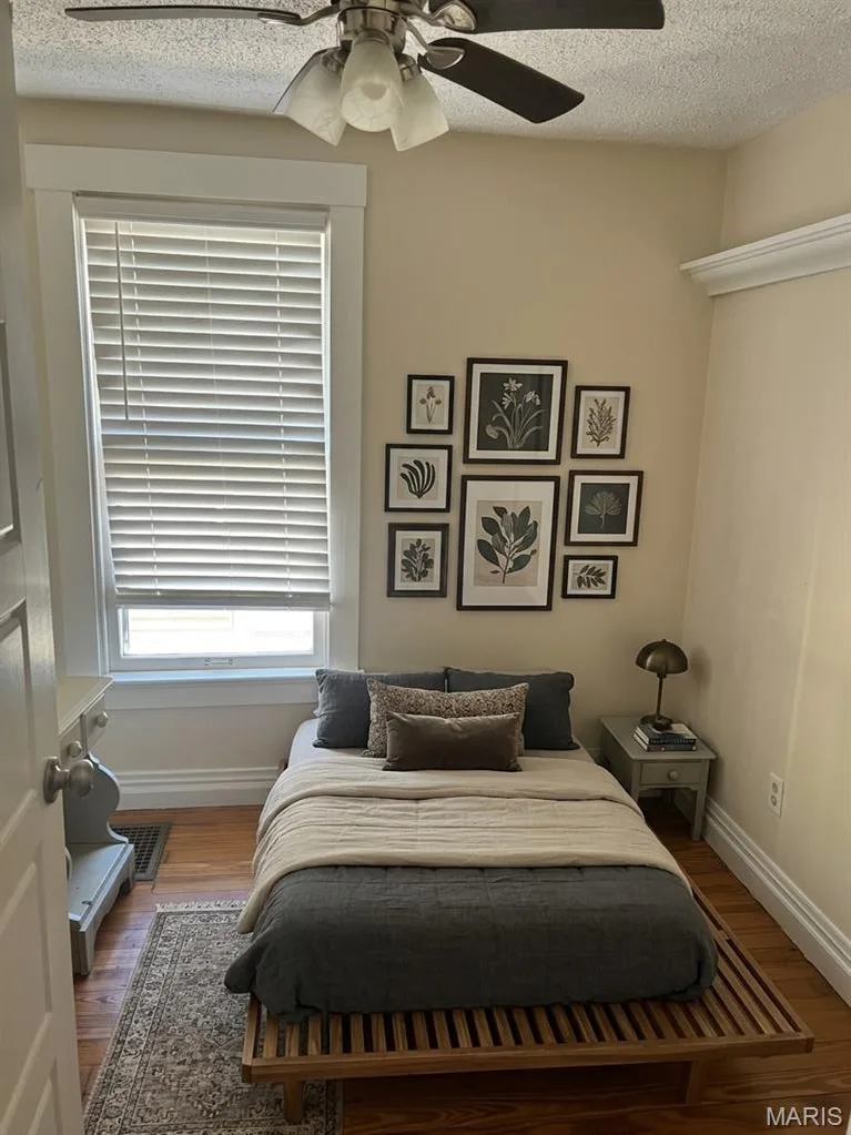 Hardwood flooring, crown molding, wide-casing window trim, and a ceiling fan with integrated lighting — 411 Adams Street, St Charles, MO 63301