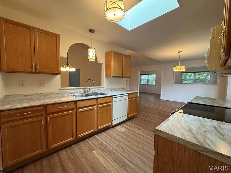 Kitchen with updated countertops, sink, faucet, and lighting. Note the skylight! — 32 Austin Hill Court, Wentzville, MO 63385