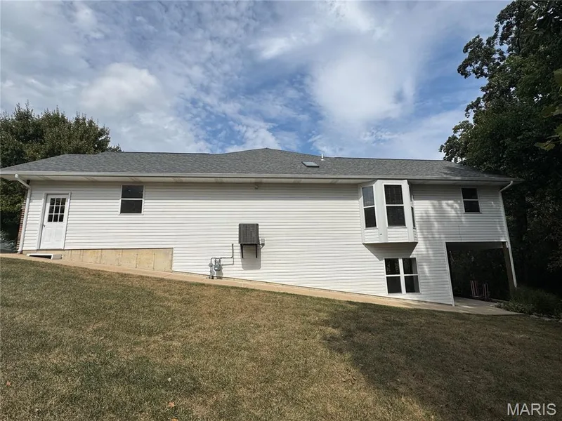Side of the villa with wide sidewalk from driveway to rear patio — 32 Austin Hill Court, Wentzville, MO 63385