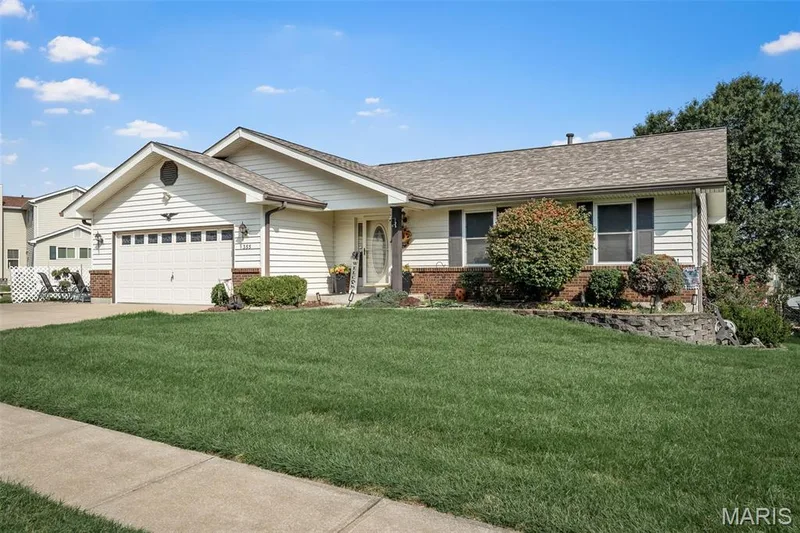 Siding exterior with brick detailing, attached garage, concrete driveway, and landscaping — 355 Birmingham Drive, O'Fallon, MO 63366