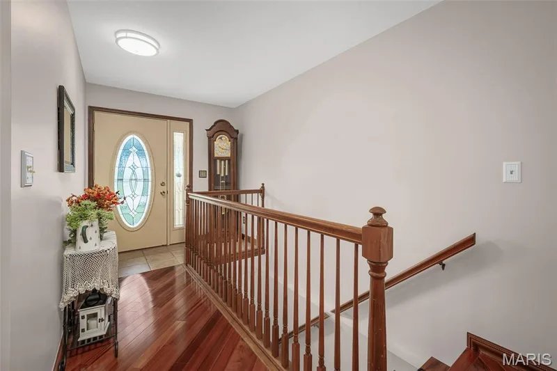 Wood-finish flooring with a complementary wood baluster railing — 355 Birmingham Drive, O'Fallon, MO 63366