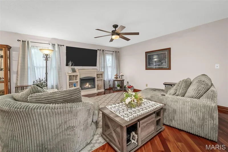 Recessed fireplace with built-in shelving, wood-finish flooring, and a ceiling fan with integrated lighting — 355 Birmingham Drive, O'Fallon, MO 63366
