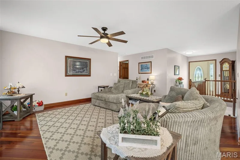 Hardwood flooring throughout, a ceiling fan with integrated lighting, and a front entry door with decorative glass panels — 355 Birmingham Drive, O'Fallon, MO 63366