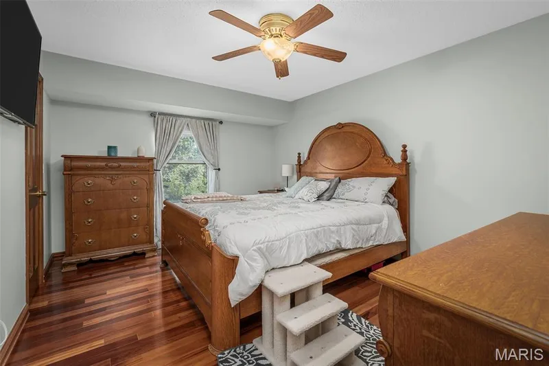 Wood-finish flooring with a ceiling fan light fixture, featuring a window with natural light and neutral wall colors — 355 Birmingham Drive, O'Fallon, MO 63366