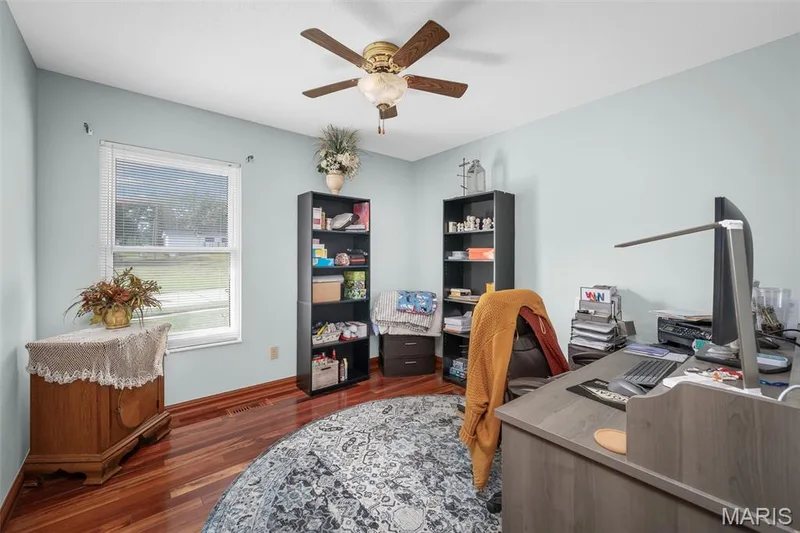 Wood-finish flooring, single window with blinds, ceiling fan, and light blue wall color — 355 Birmingham Drive, O'Fallon, MO 63366