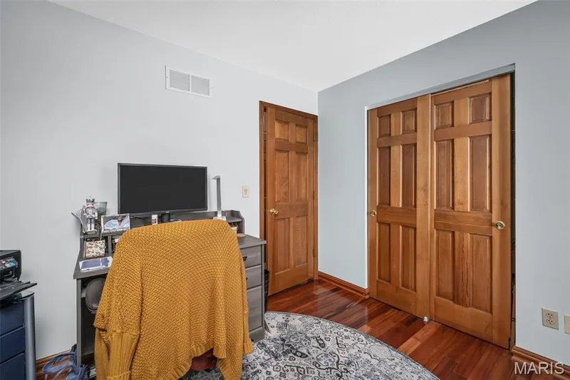 Hardwood flooring, light blue wall paint, wood paneled doors, and a built-in closet with double doors — 355 Birmingham Drive, O'Fallon, MO 63366