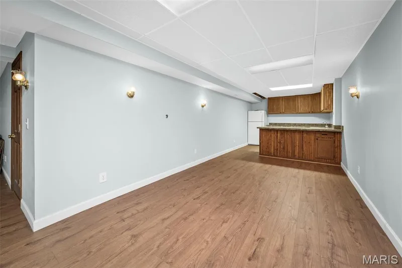 Wood-finish flooring, recessed lighting, and a built-in wet bar with wood cabinetry and countertop — 355 Birmingham Drive, O'Fallon, MO 63366