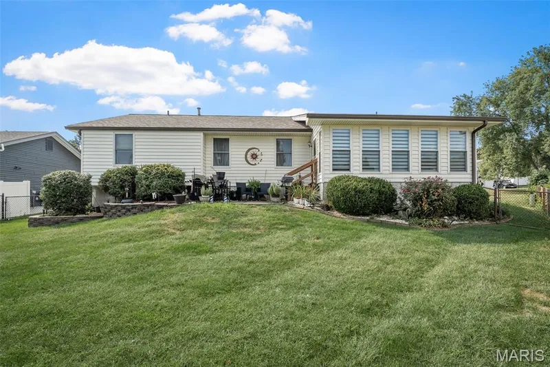 Expansive green lawn, established landscaping, and a fenced perimeter — 355 Birmingham Drive, O'Fallon, MO 63366