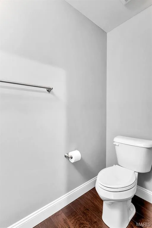Wood-finish flooring with white trim, a white toilet, and a chrome towel bar — 332 Mystic Brook Drive, O'Fallon, MO 63366