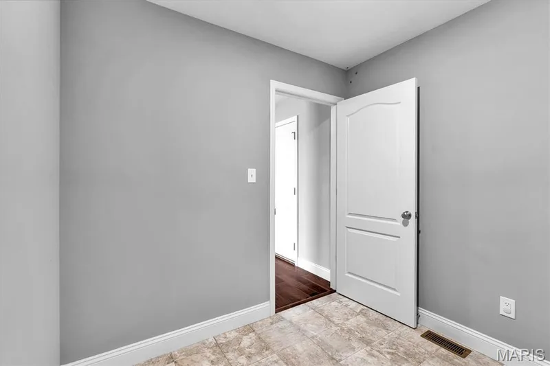Light-toned floor tiling, white baseboards, and a white interior door with a rounded top panel — 332 Mystic Brook Drive, O'Fallon, MO 63366