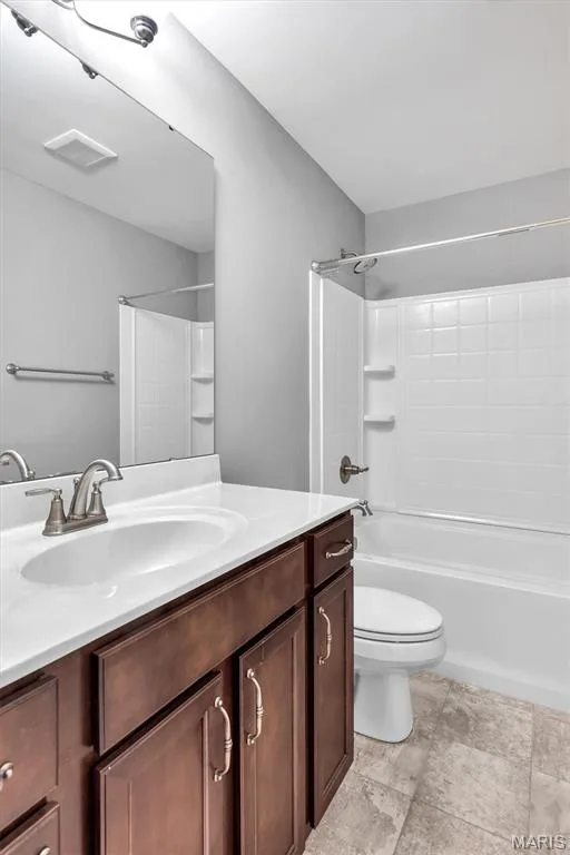 Bathroom featuring a wood-finish vanity with a white countertop, an undermount sink, and a combination shower/tub with white subway tile surround — 332 Mystic Brook Drive, O'Fallon, MO 63366