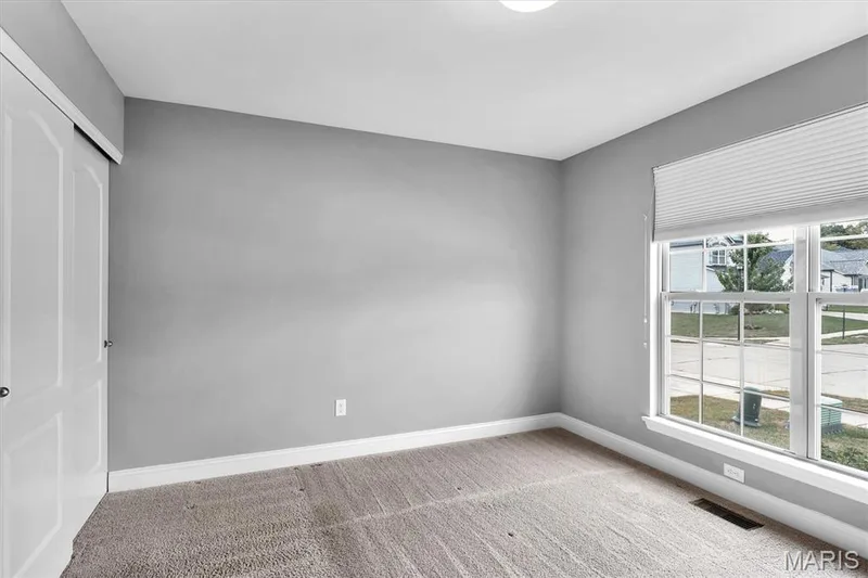 Neutral gray wall paint, carpeting, white trim, sliding closet doors, and a window with blinds — 332 Mystic Brook Drive, O'Fallon, MO 63366