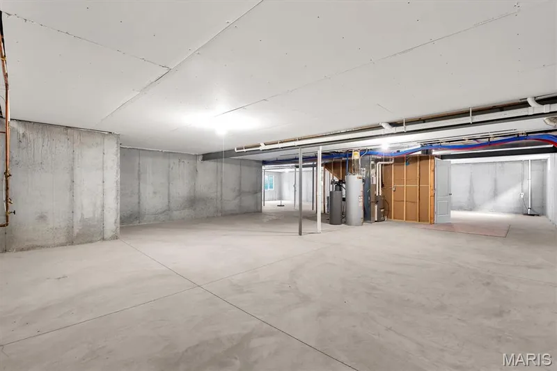 Unfinished basement with concrete walls, concrete flooring, exposed utility piping, and a water heater — 332 Mystic Brook Drive, O'Fallon, MO 63366